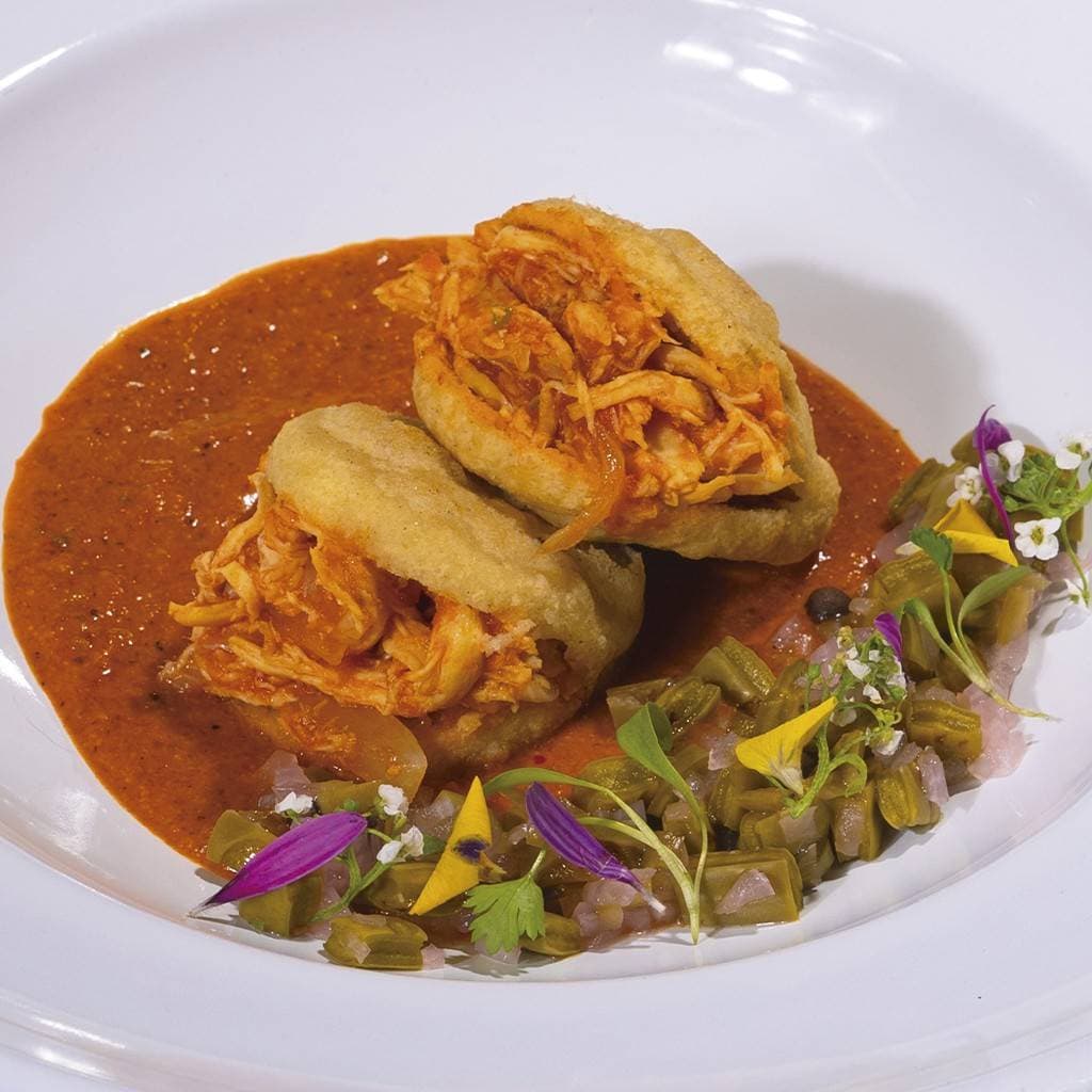 Arepa rellena con tinga de pollo sobre encacachuatado Arepa rellena con tinga de pollo sobre encacachuatado