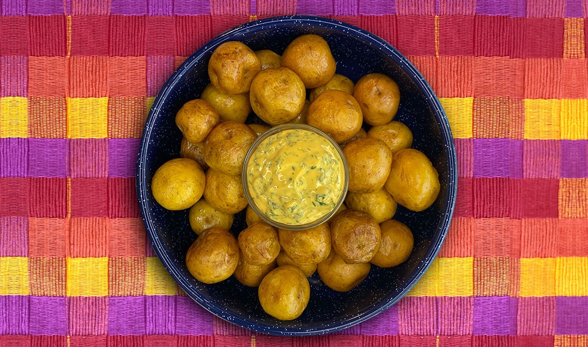 Papitas criollas con salsa de queso cheddar y cilnatro Papitas criollas con salsa de queso cheddar y cilnatro