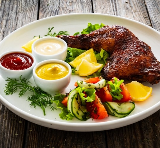 Pierna con muslo de pollo servido junto a una ensalada