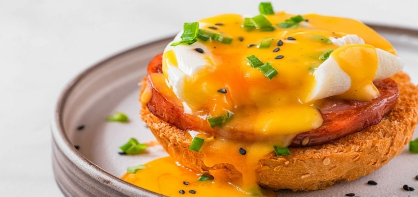 Huevos benedictinos con salsa de queso cheddar