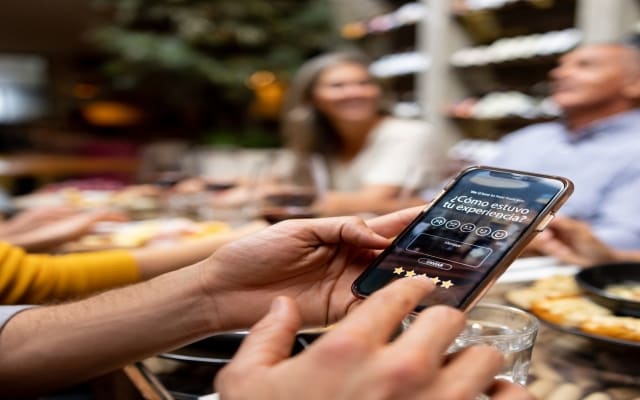 Cliente de restaurante da su feedback sobre la experiencia gastronómica durante una comida con amigos.