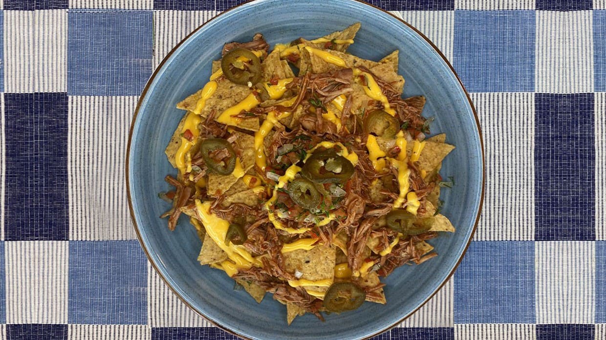 Totopos con toppings - salsa de queso, carne y jalapeños.