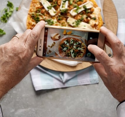 Persona tomando foto de una pizza