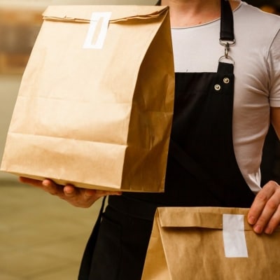 Empleado cargando bolsas de comida a domicilio